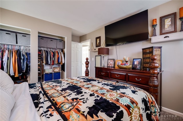 carpeted bedroom featuring baseboards and multiple closets