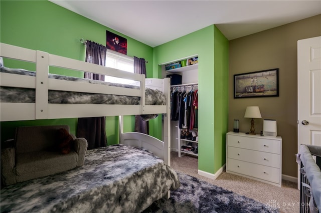 carpeted bedroom featuring a closet and baseboards