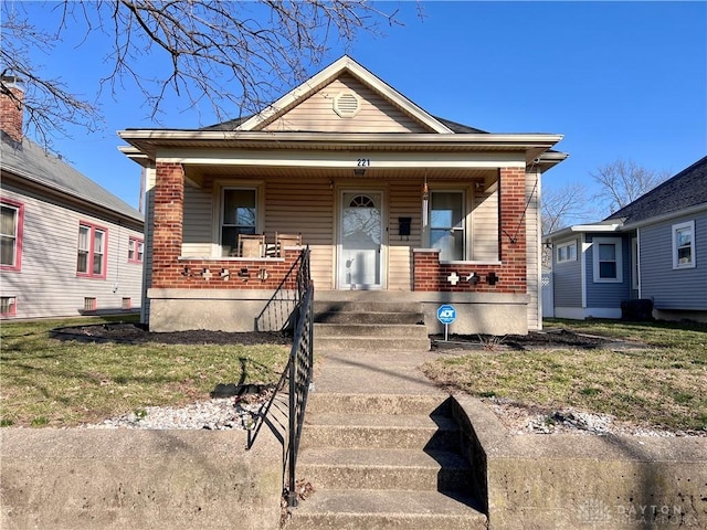 bungalow-style home with brick siding and a porch