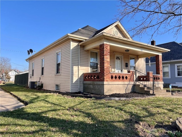 view of front of property with a front lawn, a porch, central AC unit, and brick siding