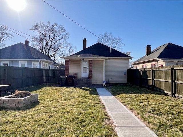 back of property with a yard and a fenced backyard