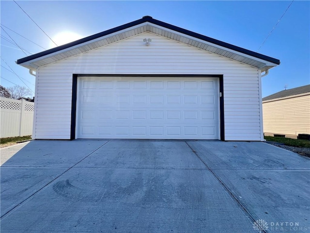 detached garage featuring fence