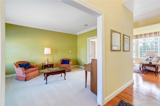 sitting room featuring wood finished floors, baseboards, carpet, and ornamental molding