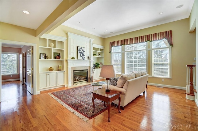 living area with visible vents, baseboards, a fireplace with flush hearth, light wood-type flooring, and recessed lighting