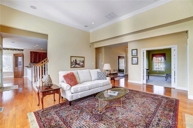 living room featuring baseboards, recessed lighting, ornamental molding, stairs, and light wood-type flooring