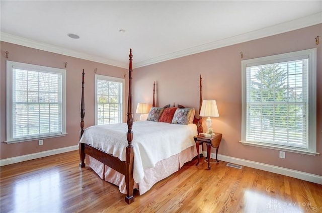 bedroom with crown molding, visible vents, and light wood-type flooring