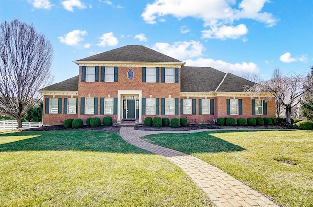 view of front of property featuring brick siding, a front yard, and fence