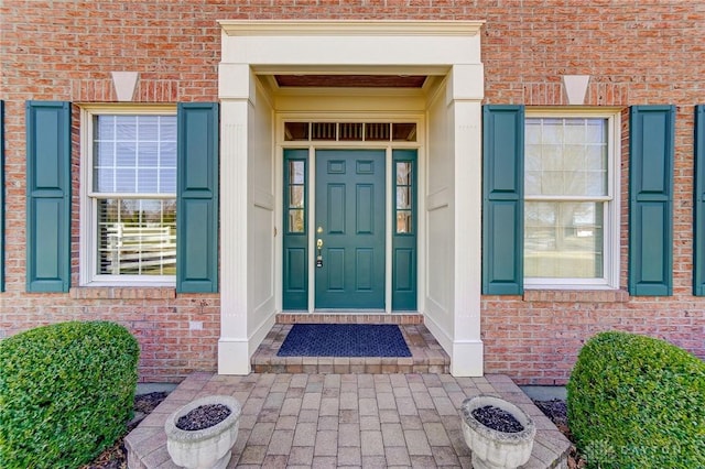 doorway to property with brick siding