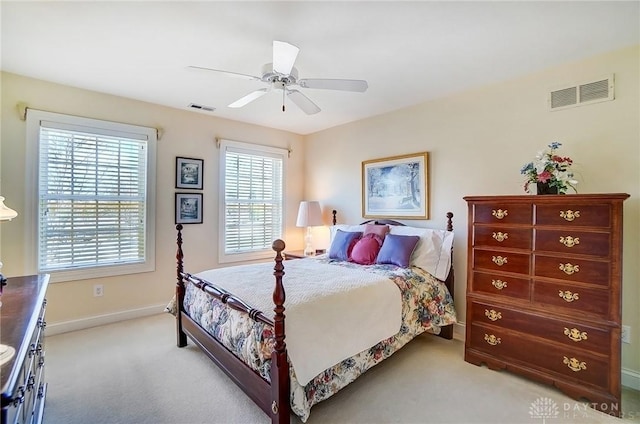 bedroom featuring visible vents, light carpet, baseboards, and ceiling fan