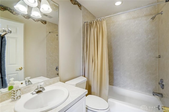 bathroom with visible vents, vanity, toilet, and shower / tub combo