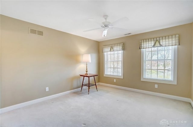 carpeted empty room with visible vents, baseboards, and ceiling fan