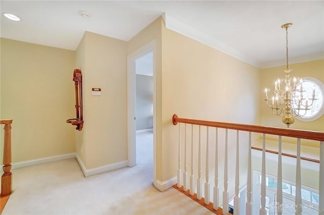 hallway featuring carpet flooring, baseboards, and an inviting chandelier