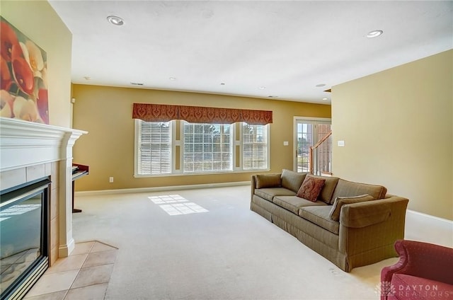 living room with a tiled fireplace, recessed lighting, light carpet, and baseboards