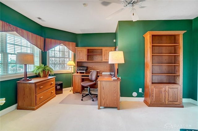 office space with baseboards, visible vents, and ceiling fan