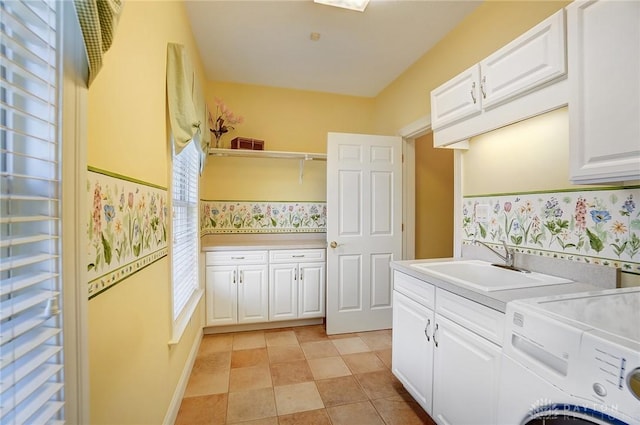 washroom with a sink, cabinet space, and independent washer and dryer