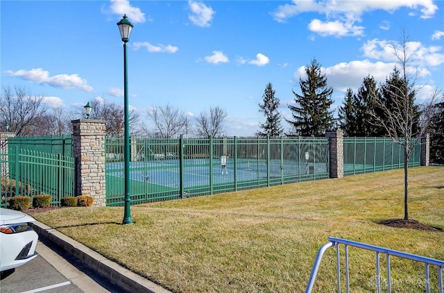 view of sport court with fence and a lawn