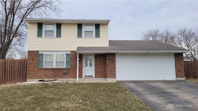 traditional-style home featuring brick siding, aphalt driveway, and fence