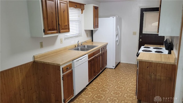 kitchen with light floors, white appliances, light countertops, and a sink