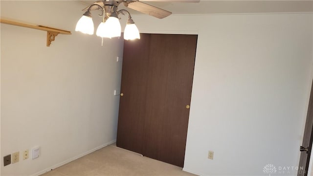 carpeted spare room with ceiling fan