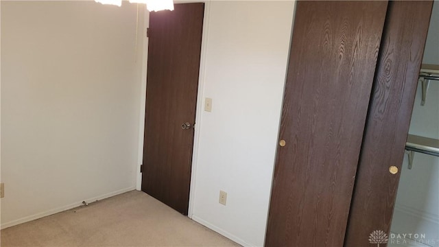 unfurnished bedroom featuring light colored carpet and baseboards