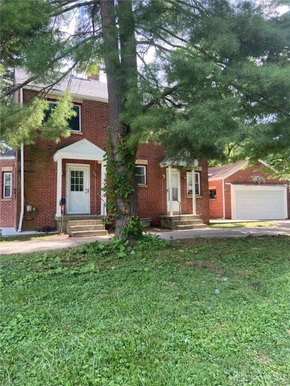 view of front of property with a garage, brick siding, a front lawn, and entry steps