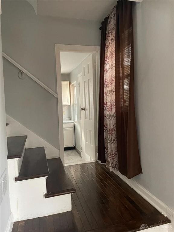 hall featuring baseboards and wood-type flooring