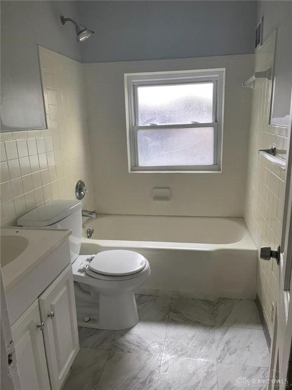 bathroom with toilet, vanity, bathtub / shower combination, marble finish floor, and tile walls