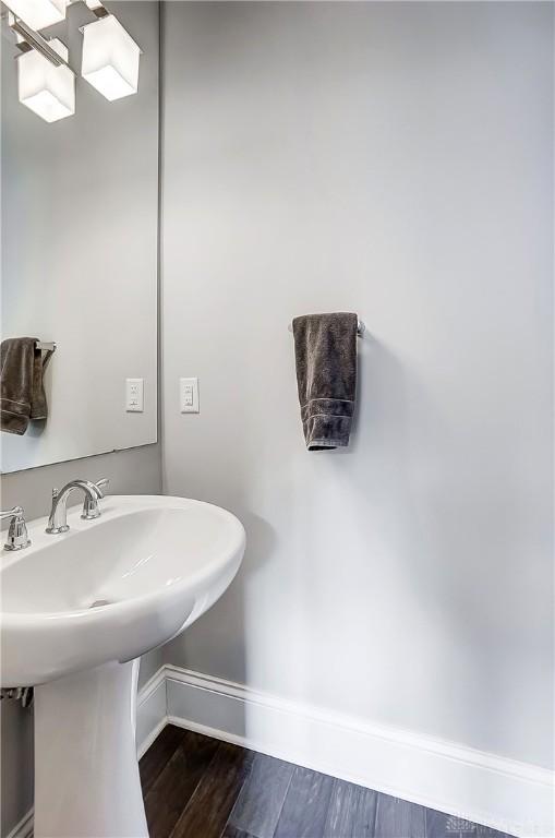 bathroom with a sink, baseboards, and wood finished floors