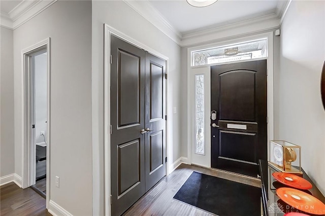 foyer entrance featuring dark wood finished floors, baseboards, and ornamental molding