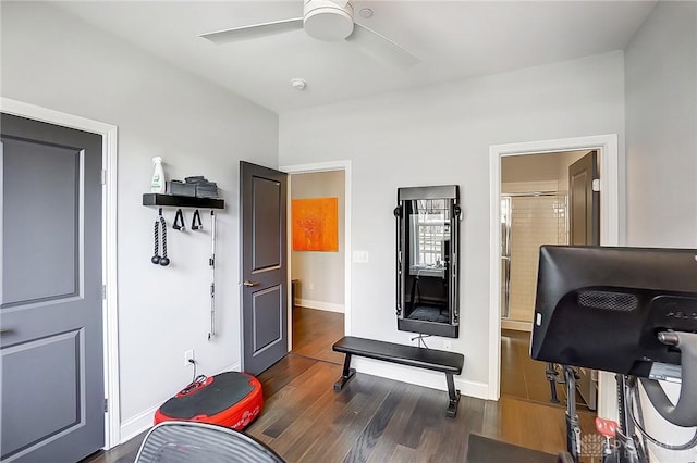 exercise area featuring baseboards, wood finished floors, and a ceiling fan