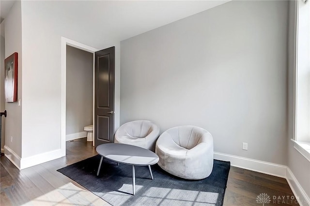 sitting room with baseboards and wood finished floors