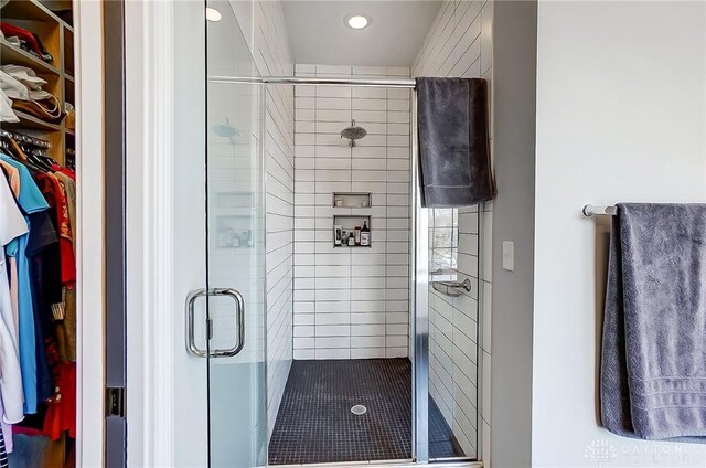 full bath featuring recessed lighting, a spacious closet, and a shower stall