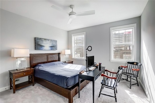 bedroom with ceiling fan, baseboards, and light carpet