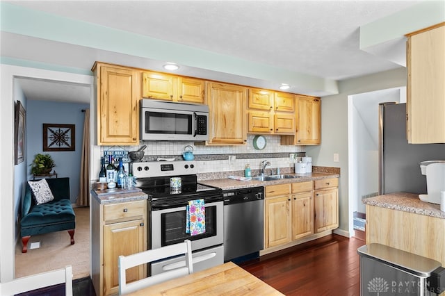 kitchen featuring a sink, stainless steel appliances, backsplash, and light countertops