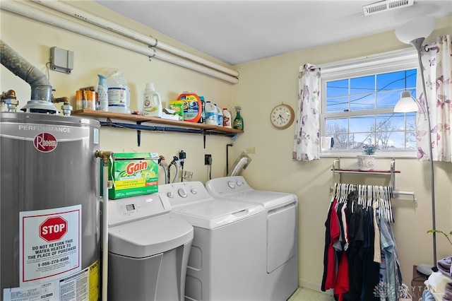 washroom with water heater, laundry area, visible vents, and separate washer and dryer