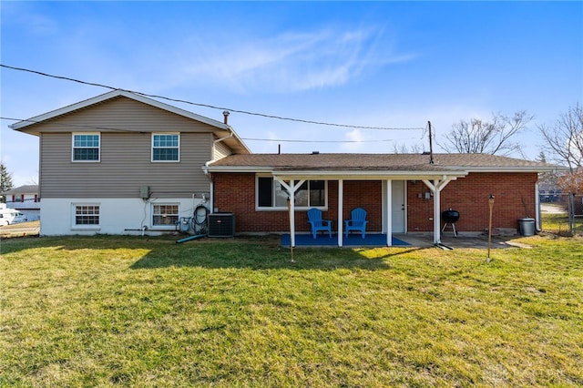 back of property with a patio, fence, central AC unit, a lawn, and brick siding