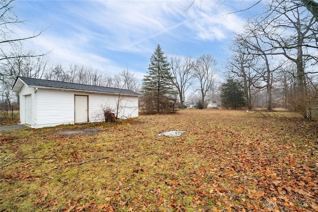 view of yard featuring a detached garage and an outdoor structure