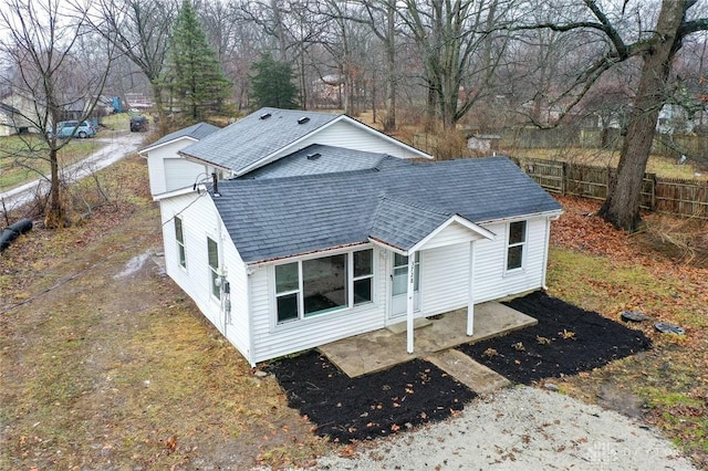 exterior space featuring a shingled roof and fence