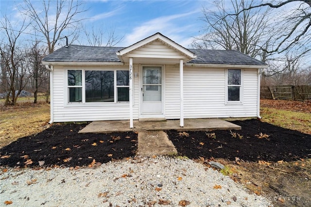 view of front of property featuring a shingled roof and fence