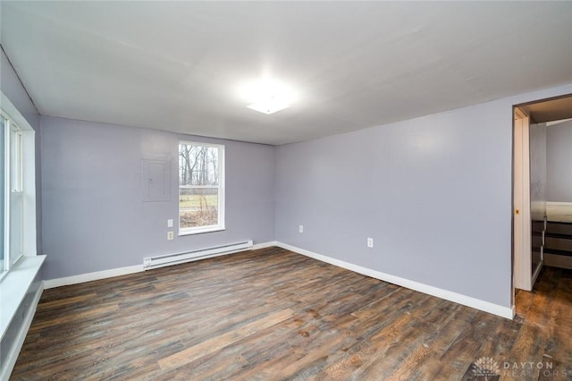 empty room featuring a baseboard radiator, baseboards, and wood finished floors