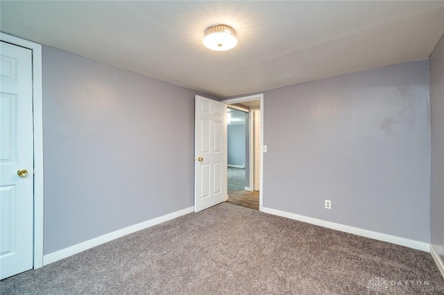 carpeted empty room with baseboards