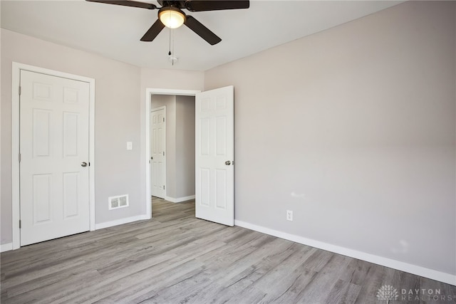 unfurnished bedroom with ceiling fan, wood finished floors, visible vents, and baseboards