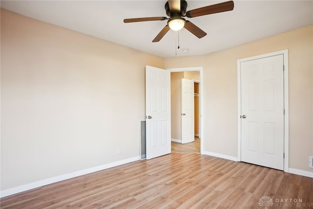 unfurnished bedroom with baseboards, light wood-style flooring, and a ceiling fan