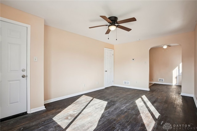 unfurnished room featuring visible vents, ceiling fan, baseboards, wood finished floors, and arched walkways