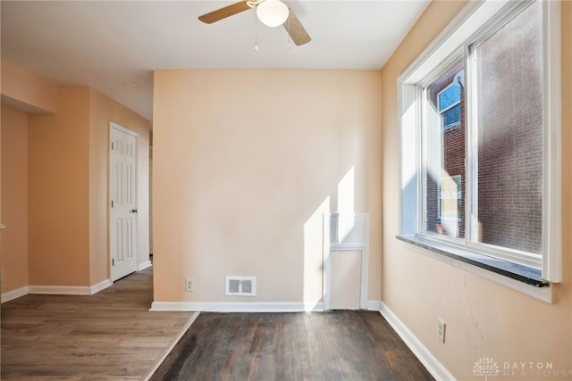 unfurnished room with visible vents, ceiling fan, baseboards, and wood finished floors