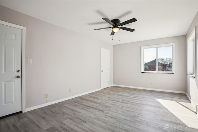 unfurnished room with ceiling fan, baseboards, and wood finished floors