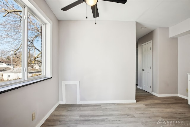 unfurnished room featuring wood finished floors, baseboards, and a wealth of natural light