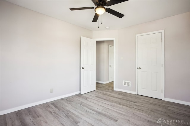 unfurnished bedroom featuring visible vents, ceiling fan, baseboards, and wood finished floors