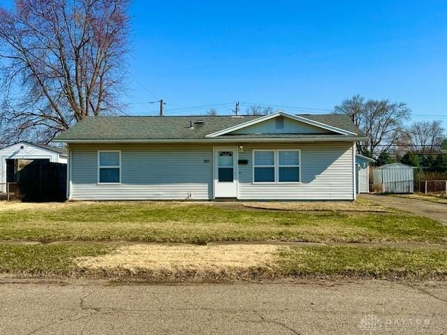 ranch-style house with an outbuilding, a storage shed, and a front lawn