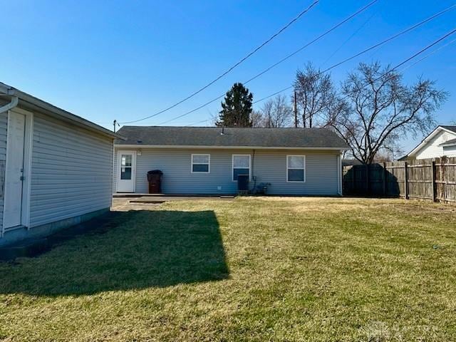 back of property with a yard and fence